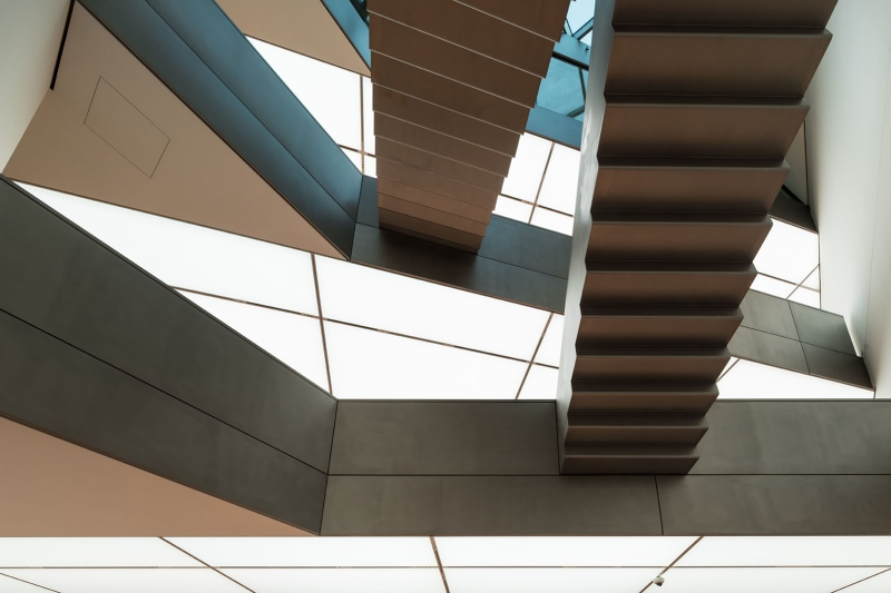 Schwebende Treppen in modernem Architekturdesign, umgeben von geometrischen Formen und hellem Licht.