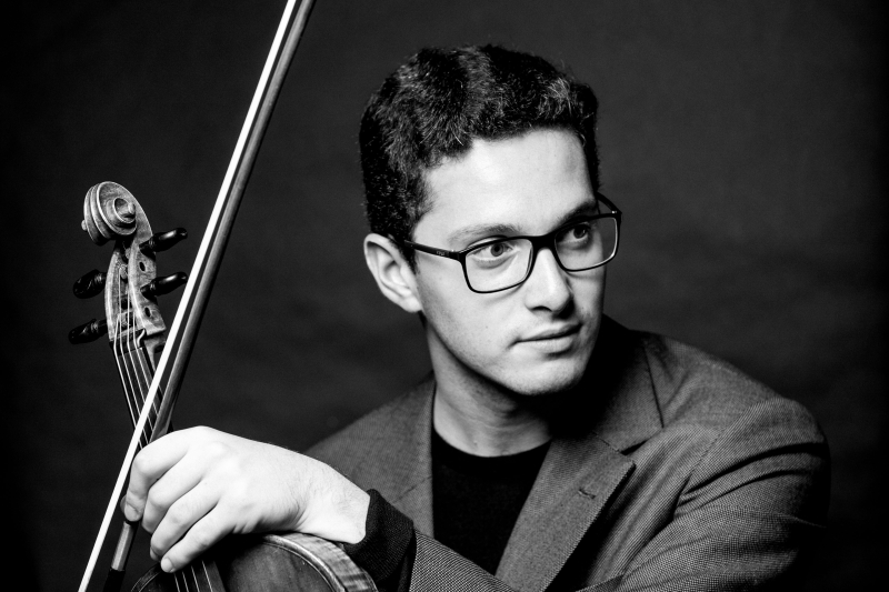 Der Musiker Hugo Max, sitzend mit eGeige und Bogen