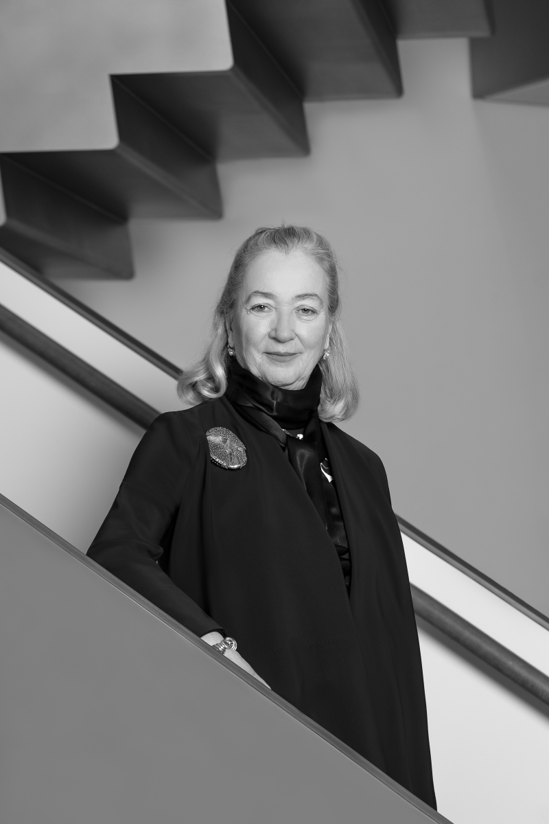 Treppenaufgang mit modernen Stufen und einem leuchtenden Herz aus Lichtern an der Wand.