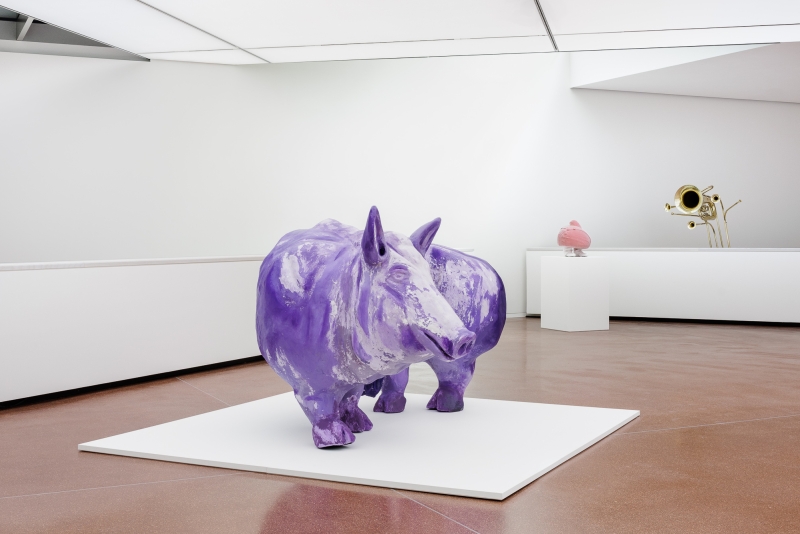 Lila Skulptur eines Tieres in einem modernen Ausstellungsraum mit minimalistischer Einrichtung.