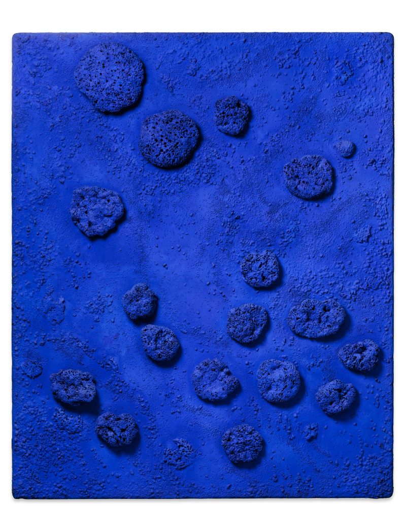The artwork is a rectangular relief - a kind of picture with three-dimensional shapes. It is painted entirely in intense ultramarine blue, a color that made Yves Klein famous. This color appears luminous, deep and almost physical - as if it were absorbing light.
Real natural sponges and small pebbles are attached to the surface. They are irregularly distributed and protrude from the surface. Some are rounded, others rather flat or porous. The sponges cast fine shadows, depending on the incidence of light - this gives the work a lively, animated structure.
The surface itself is not smooth, but slightly grainy and rough. There, too, you can see small elevations that look as if the paint has naturally settled over the surface, like sand collecting on the seabed.
The sponges are completely saturated with Yves Klein's special blue paint - they almost look like small celestial bodies or deep-sea animals. Although the work does not depict a figure, it appears organic and alive.