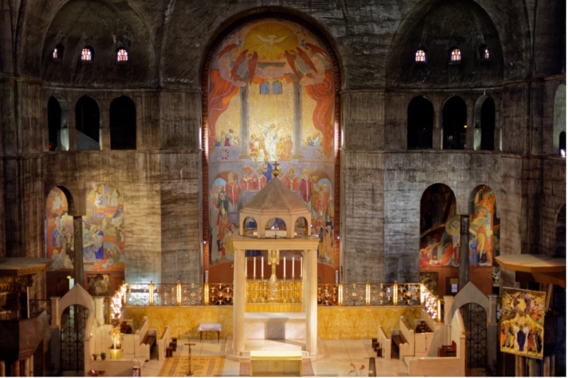 Interior of Église Saint-Esprit featuring a central altar, vibrant murals, and a high arched ceiling.