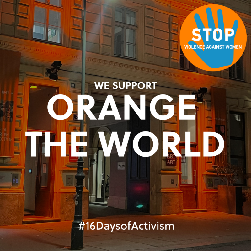Beleuchtete Fassade eines Gebäudes in Orange mit Schriftzug „We support Orange the World“ und Symbol gegen Gewalt an Frauen.