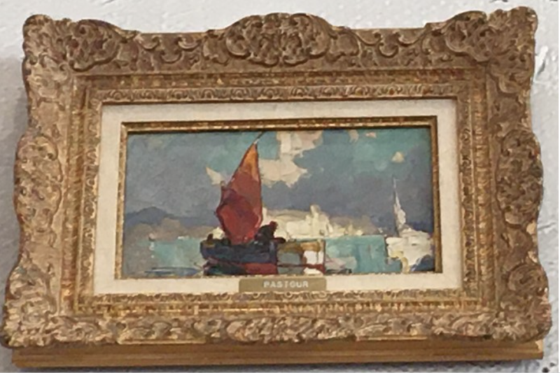 A framed painting depicts a boat with a red sail on blue water, against a backdrop of clouds and distant buildings.