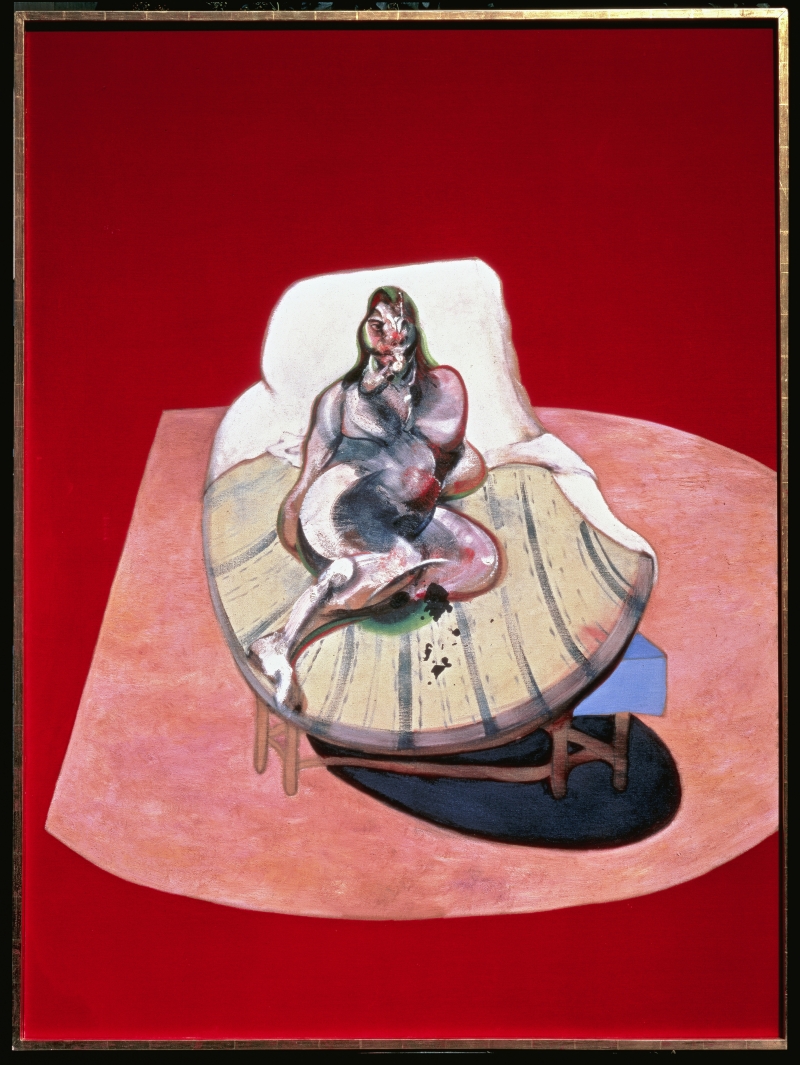 A reclining figure with exaggerated features lies on a round table against a bold red background.