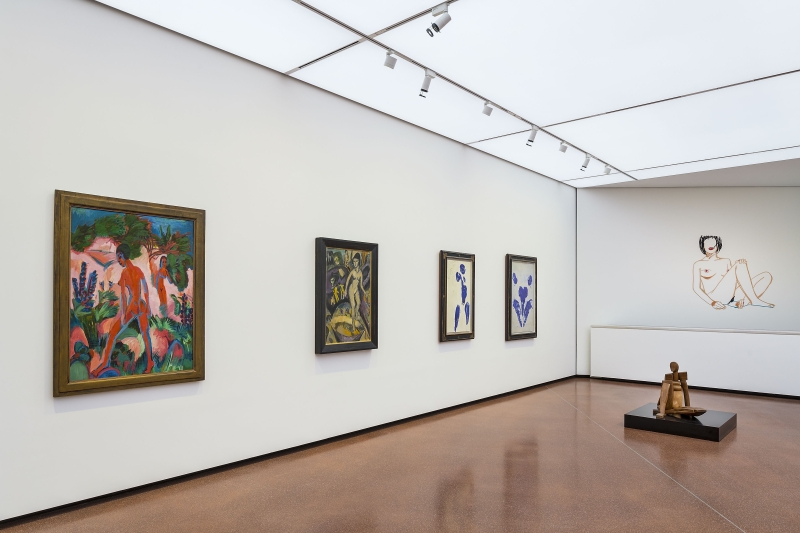 Kunstgalerie mit vier Gemälden an der Wand und einer Skulptur auf dem Boden, helle Decke und glatter Boden.