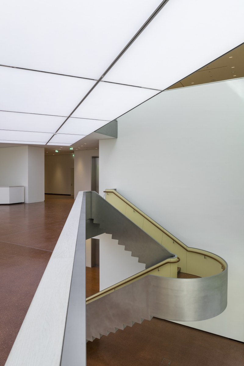Heller Innenraum mit geschwungener Treppe, weißen Wänden und einem modernen, minimalistischen Design.