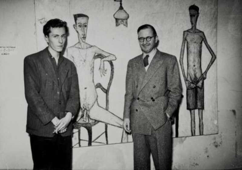 Two men stand beside a large abstract painting featuring elongated figures, one seated and another standing.