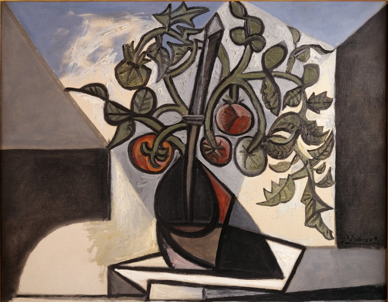 Still life featuring a dark vase with tomato plants, red tomatoes, and green leaves against a muted background.