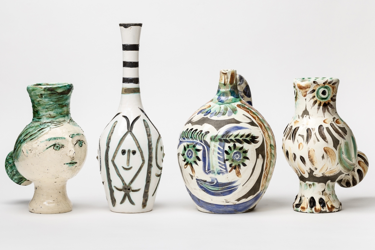 Vier kunstvolle Keramiken in verschiedenen Formen und Farben, darunter ein Gesicht und eine Vogelgestalt.